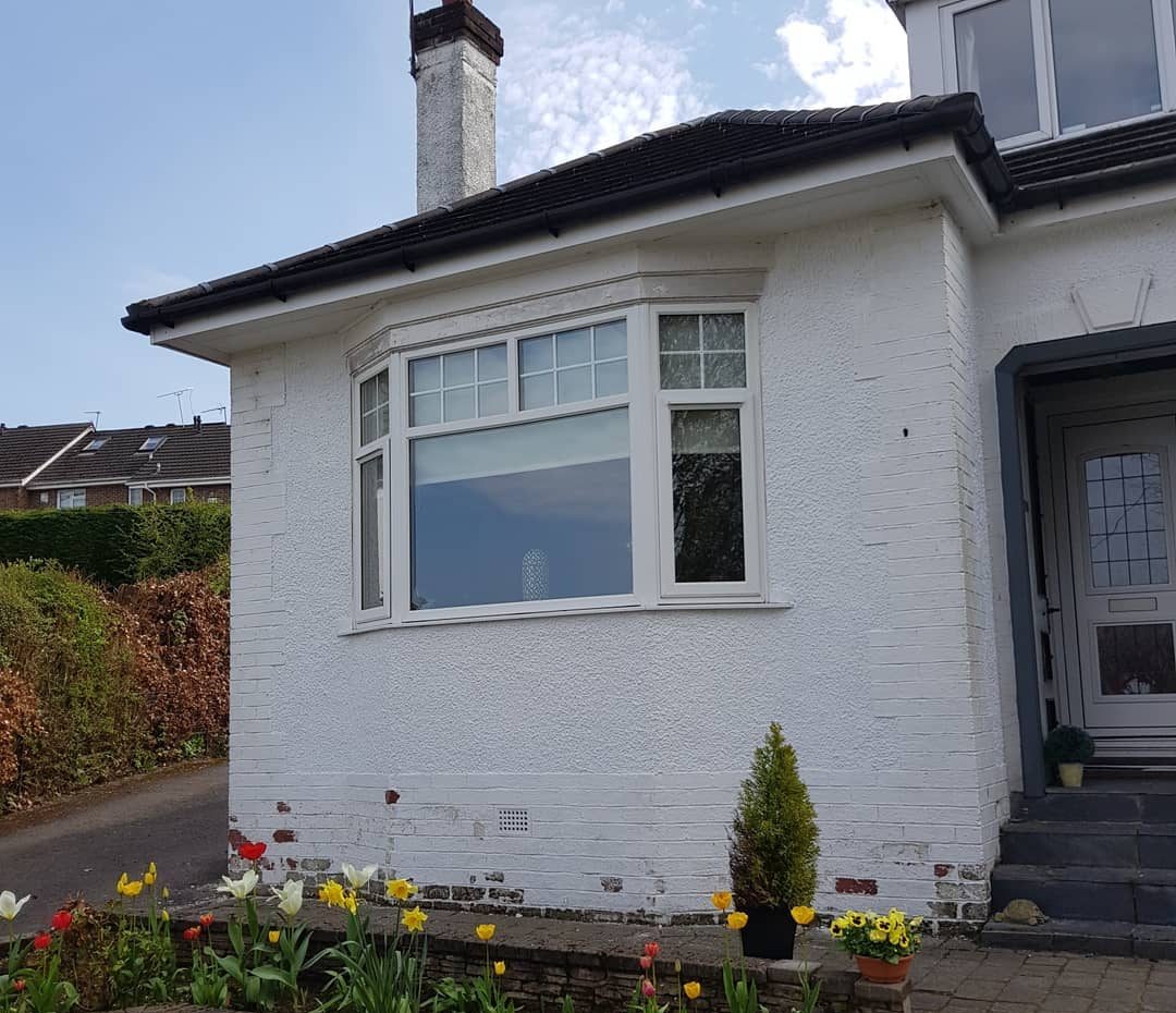 Before: a bungalow front with flaking paint and bare brick