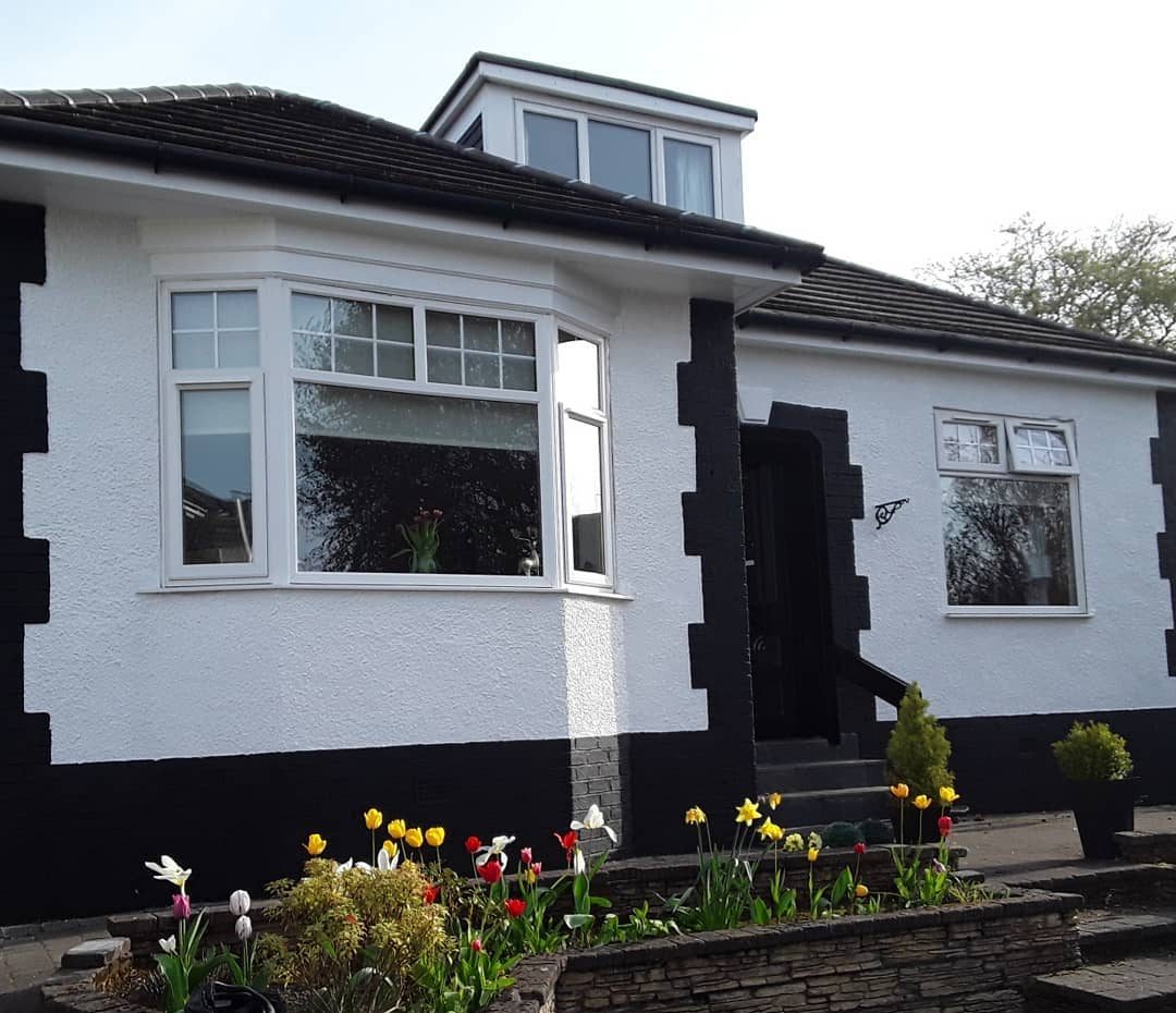 After: the same bungalow front painted white, with black quoins, base and door surround