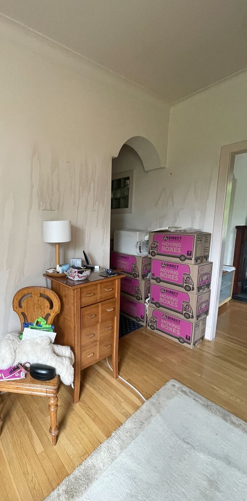 Before: a hall with water-stained walls and boxes stacked