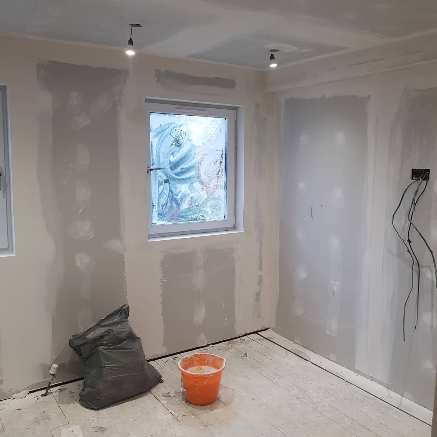A room of new plasterboard with every joint and screw taped and filled, ready for paint